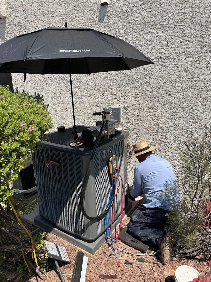 HVAC technician performing outdoor AC maintenance in Stonington